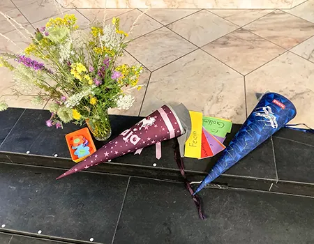 Schultüten und Blumen auf einer Treppenstufe in der Kirche