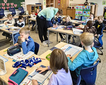 Spieler gibt im Klassenraum den Kindern Autogramme