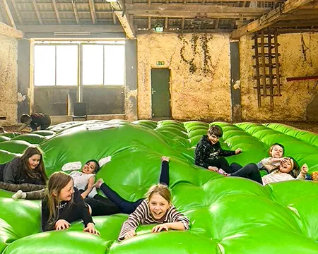 Spielende Kinder auf grünem Hüpfkissen